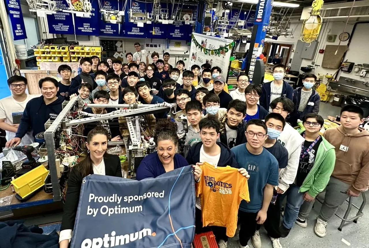 Team 2638 with an Optimum sponsorship banner